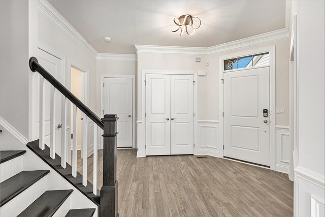 entryway with crown molding and hardwood / wood-style flooring