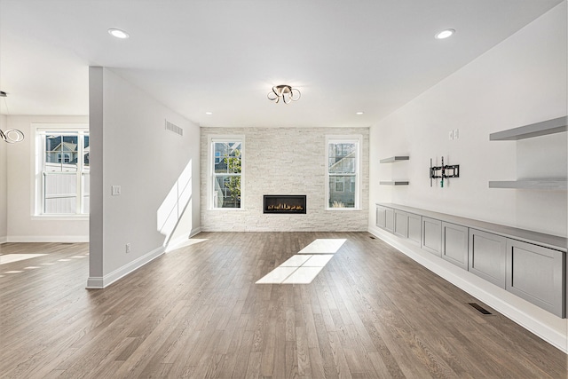 unfurnished living room featuring a fireplace and dark wood-type flooring