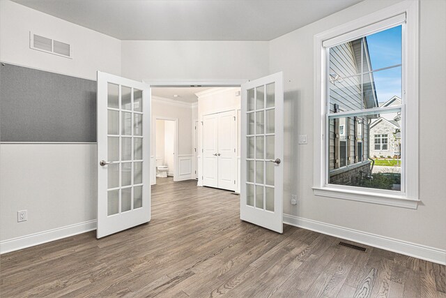 unfurnished room with french doors, dark wood-type flooring, and a healthy amount of sunlight