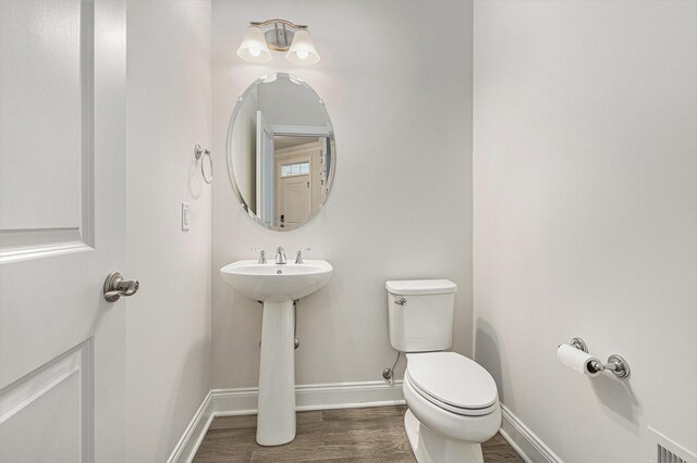 bathroom featuring hardwood / wood-style flooring and toilet