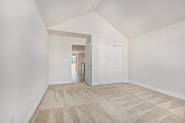 empty room featuring light colored carpet and high vaulted ceiling