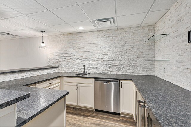 kitchen with sink, pendant lighting, hardwood / wood-style flooring, dishwasher, and white cabinetry