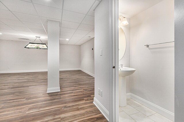 bathroom with hardwood / wood-style floors and a paneled ceiling