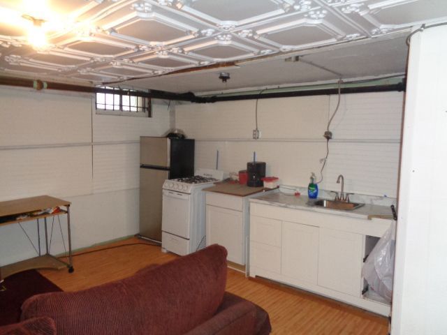 interior space featuring white cabinetry, sink, light hardwood / wood-style floors, and white appliances