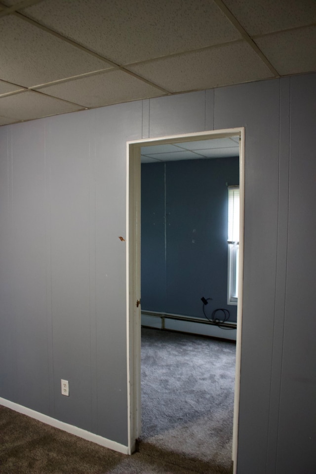 hall featuring a paneled ceiling, carpet floors, and a baseboard radiator