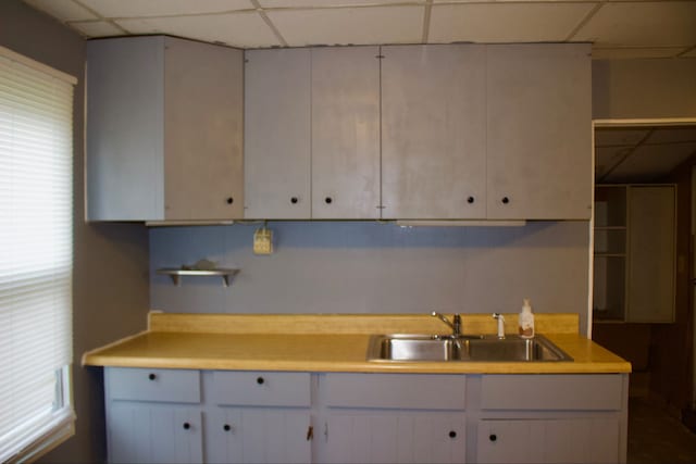 kitchen with a paneled ceiling and sink