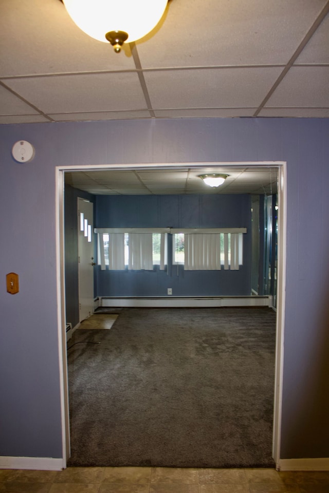 corridor featuring a drop ceiling, carpet, and a baseboard radiator