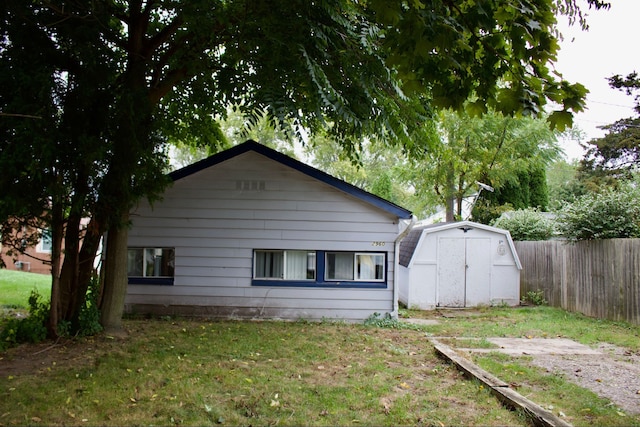 exterior space featuring a lawn and a storage unit