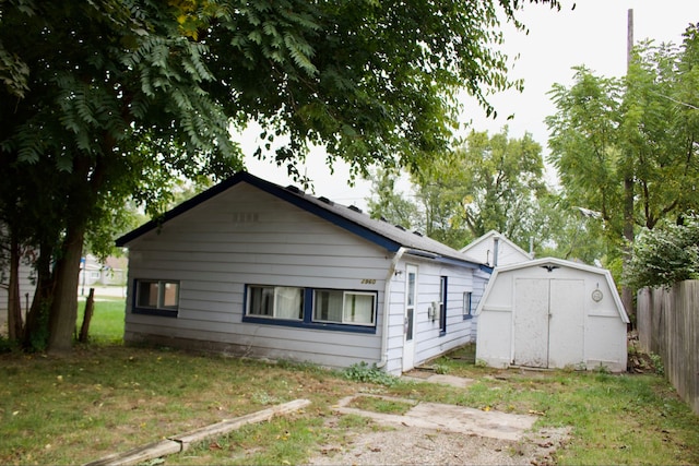 exterior space featuring a lawn and a storage shed