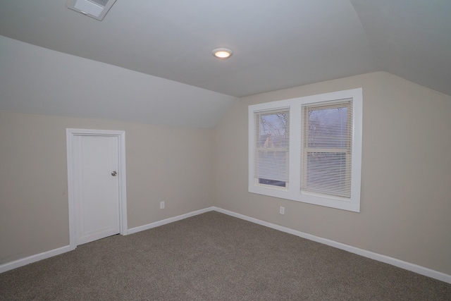 additional living space with vaulted ceiling and carpet flooring