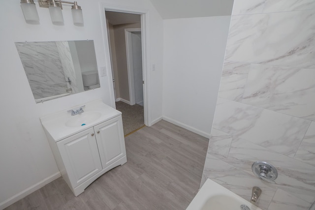 bathroom featuring shower / washtub combination, wood-type flooring, and vanity