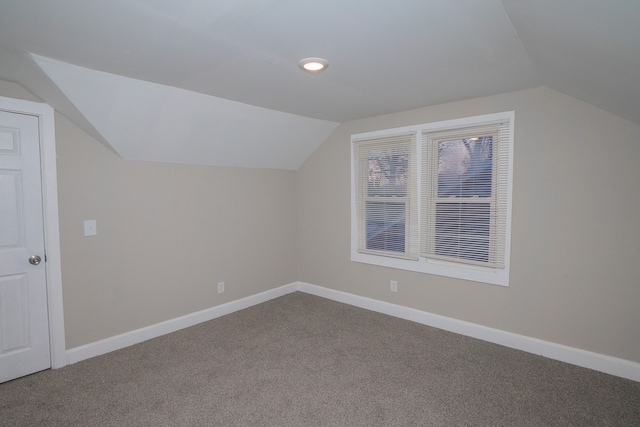 bonus room with vaulted ceiling and carpet flooring