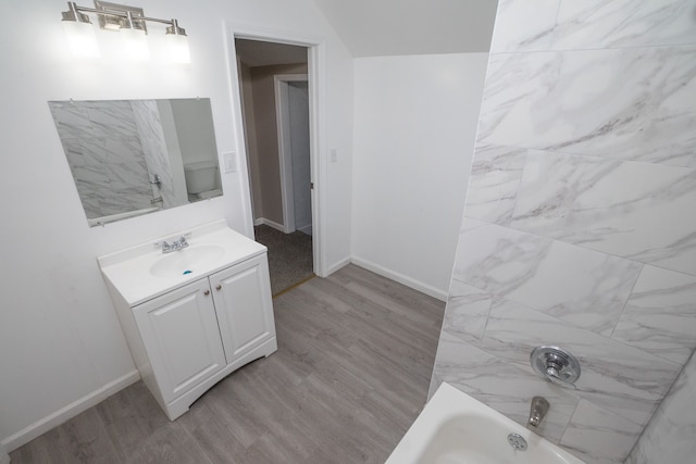 full bathroom featuring vanity, wood-type flooring, shower / bathtub combination, and toilet