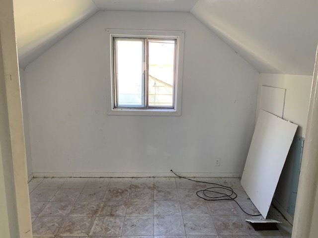 additional living space featuring vaulted ceiling