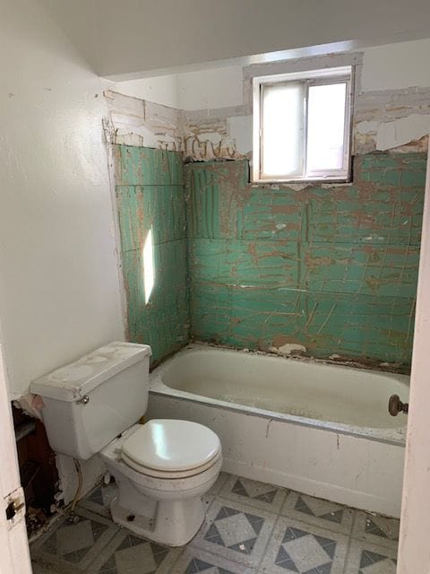 bathroom with bathing tub / shower combination and toilet