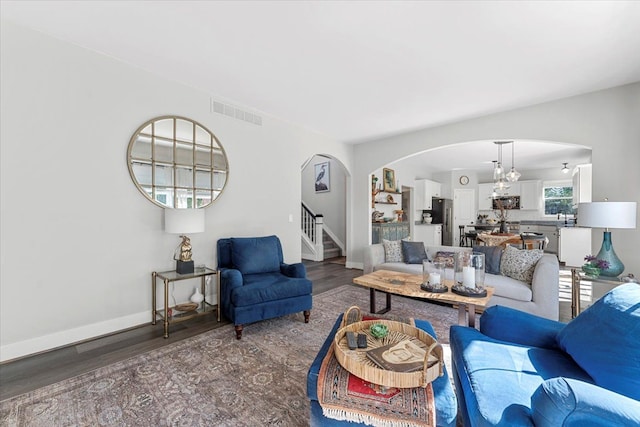 living room with hardwood / wood-style floors and a notable chandelier