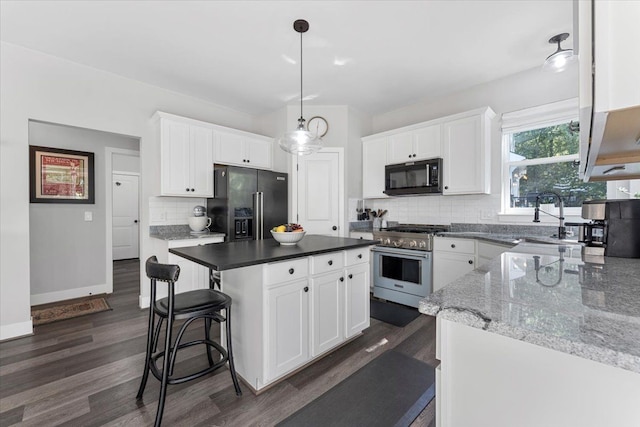 kitchen featuring a center island, high end appliances, white cabinetry, and dark wood-type flooring