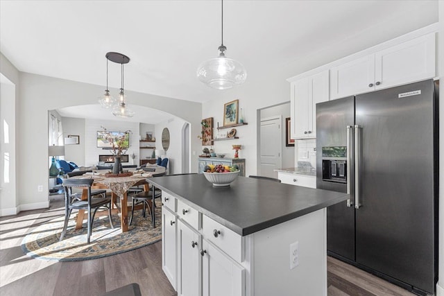 kitchen with white cabinetry, high end fridge, dark wood-type flooring, and decorative light fixtures