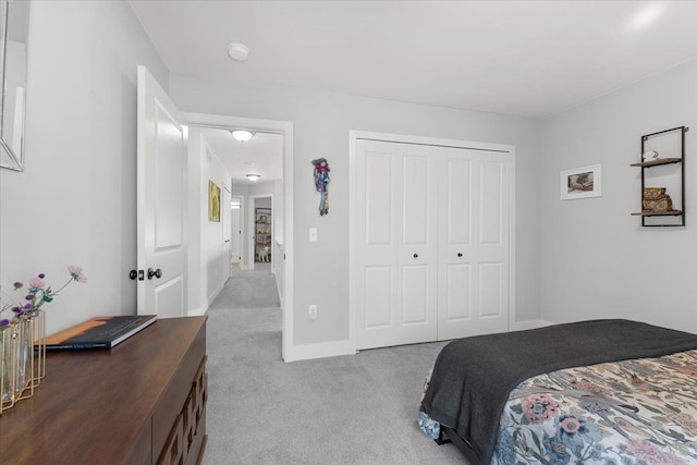 bedroom featuring light carpet and a closet