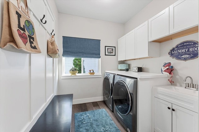 laundry area featuring sink, cabinets, separate washer and dryer, and dark wood-type flooring