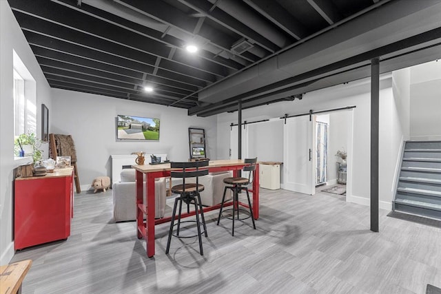 interior space with light hardwood / wood-style floors and a barn door