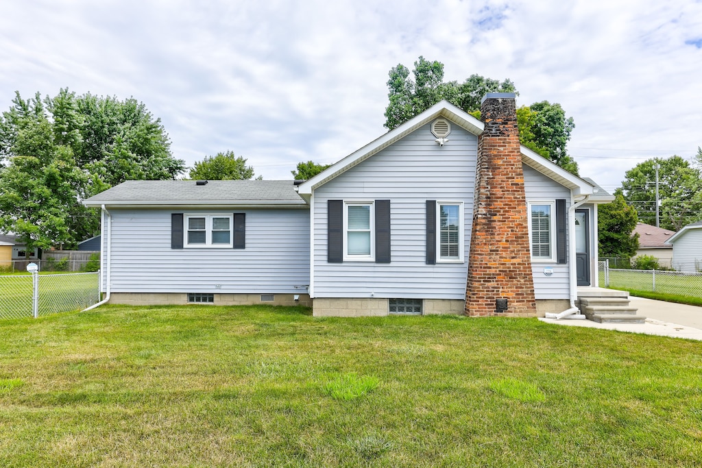 rear view of house featuring a yard