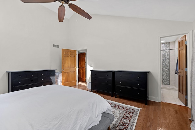 bedroom featuring ceiling fan, dark hardwood / wood-style flooring, lofted ceiling, and connected bathroom