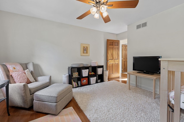 living area featuring ceiling fan and hardwood / wood-style flooring