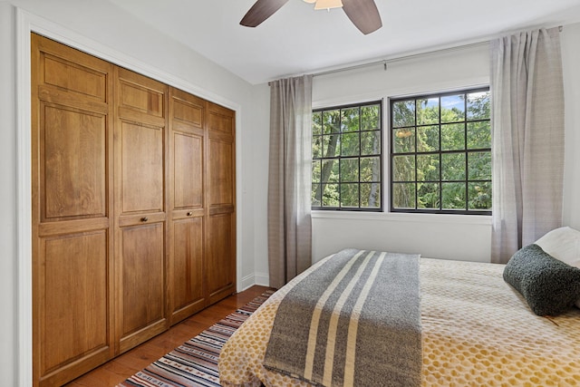 bedroom with a closet, hardwood / wood-style flooring, and ceiling fan