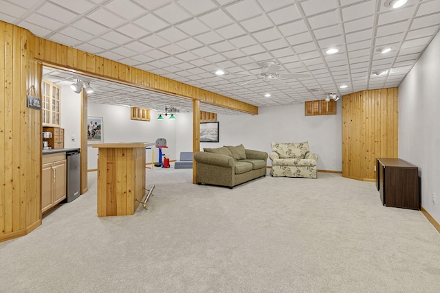 living room with bar area, wood walls, and light colored carpet