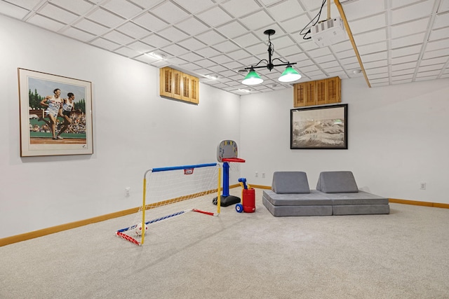 rec room with carpet flooring and a paneled ceiling