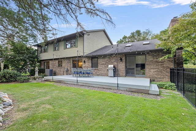 rear view of house with a yard, a wooden deck, and central air condition unit