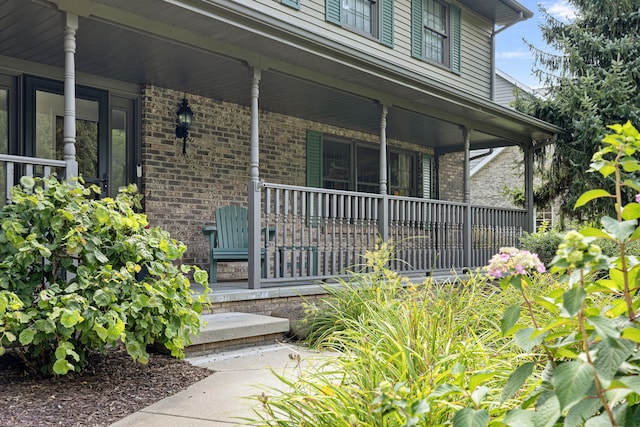 view of exterior entry featuring covered porch