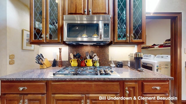 interior space with stainless steel appliances, washer and clothes dryer, and backsplash