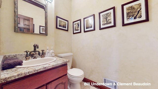 bathroom featuring vanity, tile patterned flooring, and toilet