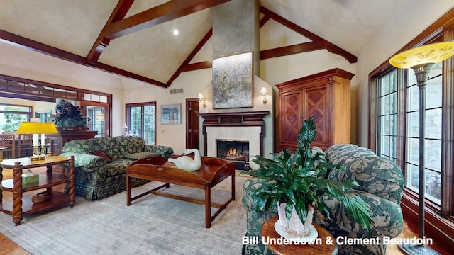 living room featuring a healthy amount of sunlight, a fireplace, high vaulted ceiling, and beam ceiling