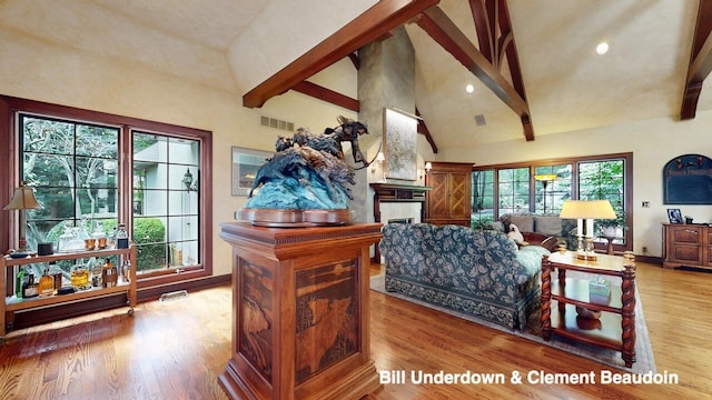 living room with beamed ceiling, hardwood / wood-style floors, and high vaulted ceiling