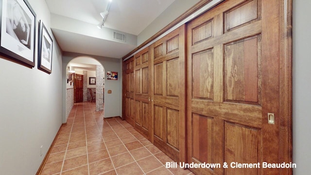 corridor with light tile patterned floors and rail lighting