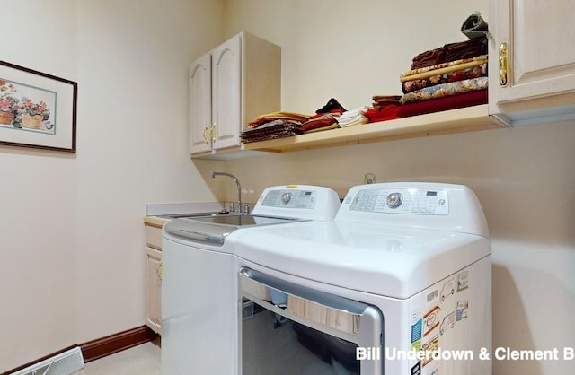 laundry area featuring cabinets, sink, and washer and clothes dryer