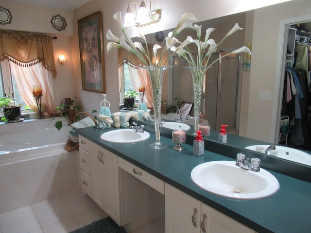 bathroom with tile patterned floors, tiled tub, and vanity