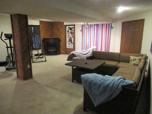 carpeted living room featuring wooden walls and a textured ceiling