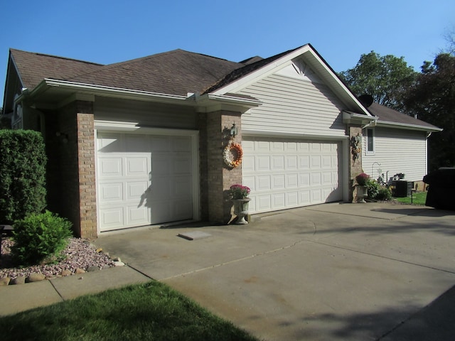 view of side of property with central AC unit and a garage