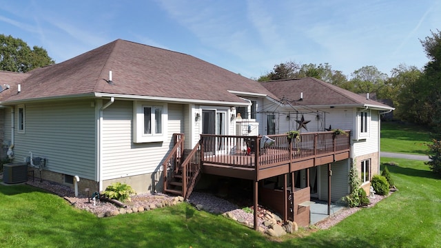 back of house featuring central air condition unit, a deck, and a lawn