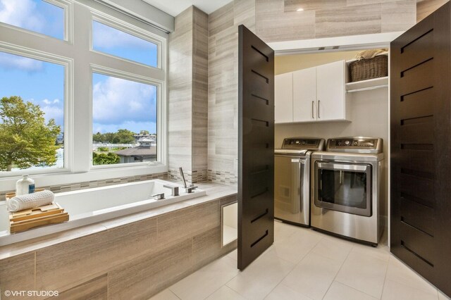 10 Peninsula Dr, New Buffalo, MI 49117 - laundry room with cabinet space, washer and clothes dryer, light tile patterned floors, and plenty of natural light