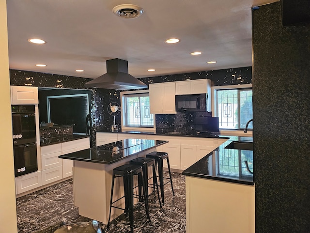 kitchen with a wealth of natural light, white cabinetry, a center island, and black appliances