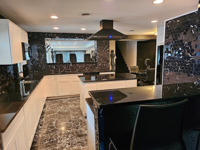 kitchen featuring a center island, island range hood, white cabinetry, and sink