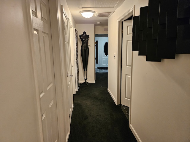 hallway featuring dark colored carpet