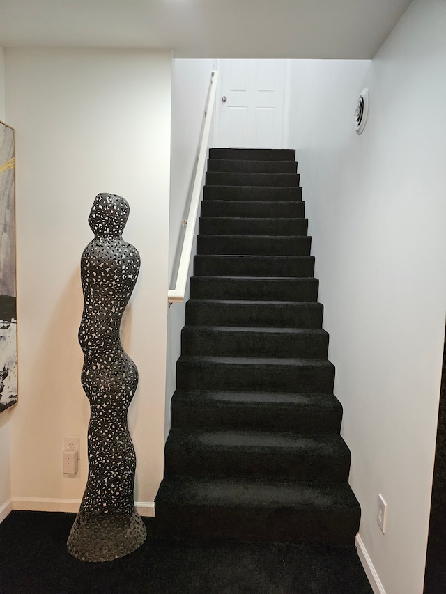 stairway featuring carpet floors