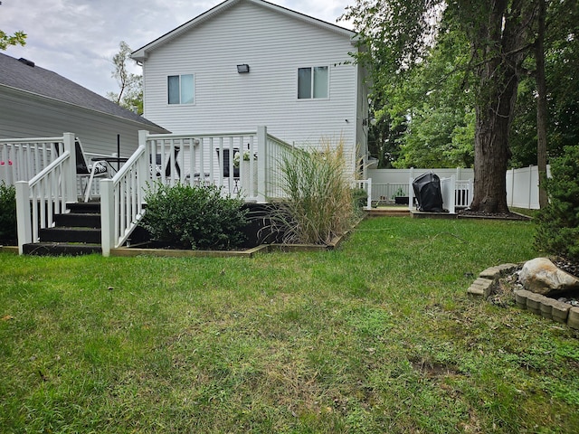 back of property featuring a lawn and a deck