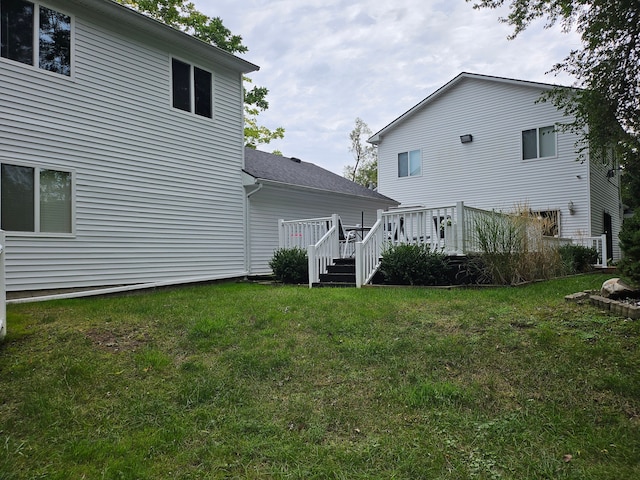 rear view of house with a deck and a yard